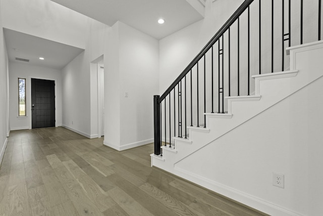 foyer entrance featuring recessed lighting, wood finished floors, visible vents, baseboards, and stairway