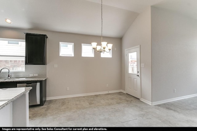 kitchen featuring lofted ceiling, pendant lighting, stainless steel dishwasher, sink, and light stone counters