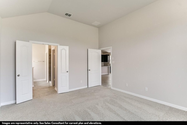 unfurnished bedroom featuring high vaulted ceiling and light colored carpet