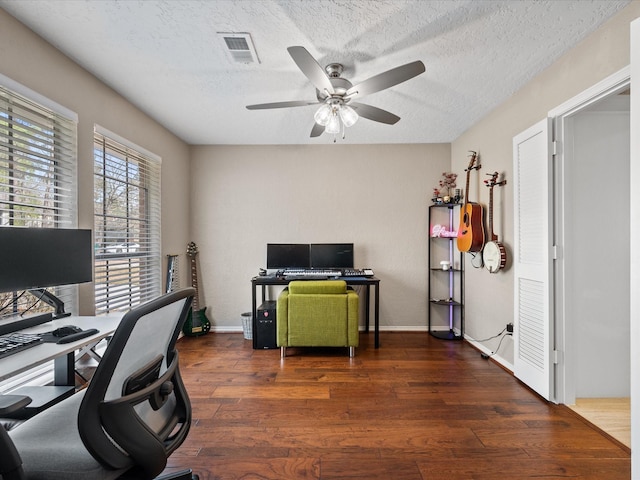 home office with ceiling fan, dark hardwood / wood-style floors, and a textured ceiling