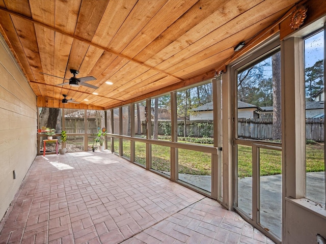 unfurnished sunroom with wooden ceiling and ceiling fan