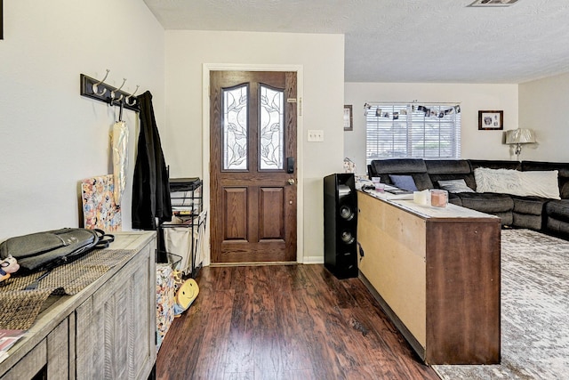 foyer with a textured ceiling and dark wood-type flooring