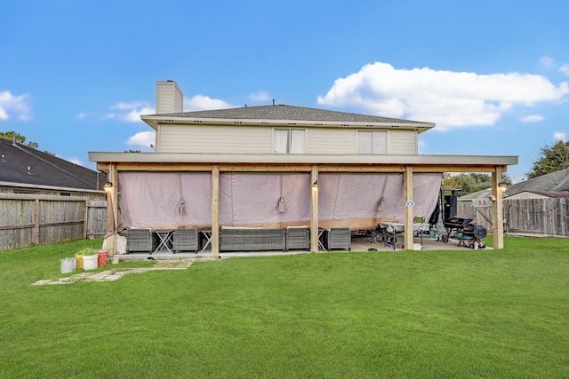 back of house with a patio area and a yard