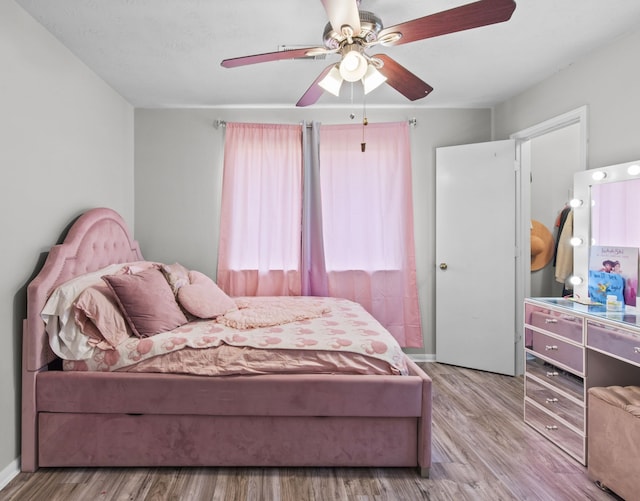 1711 Village Court Ln, Rosenberg, TX 77471 - bedroom with baseboards, wood finished floors, and ceiling fan