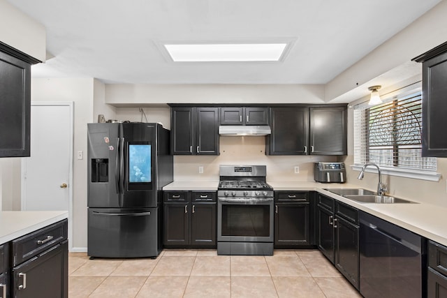 1711 Village Court Ln, Rosenberg, TX 77471 - kitchen with under cabinet range hood, stainless steel appliances, light countertops, and a sink