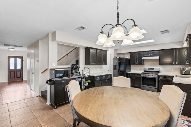 1711 Village Court Ln, Rosenberg, TX 77471 - kitchen featuring light countertops, visible vents, an inviting chandelier, and appliances with stainless steel finishes