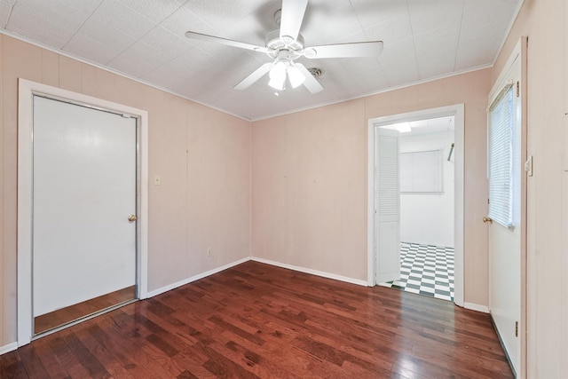 unfurnished room with dark wood-type flooring, crown molding, and ceiling fan