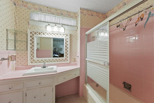 bathroom with bath / shower combo with glass door, tile patterned flooring, and vanity