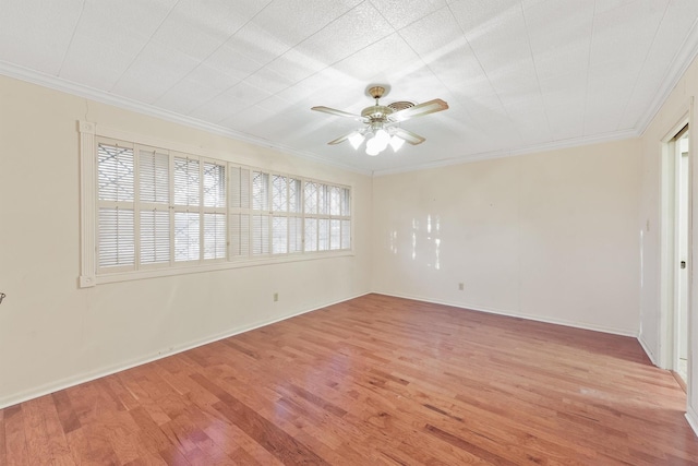 spare room with ceiling fan, ornamental molding, and light wood-type flooring