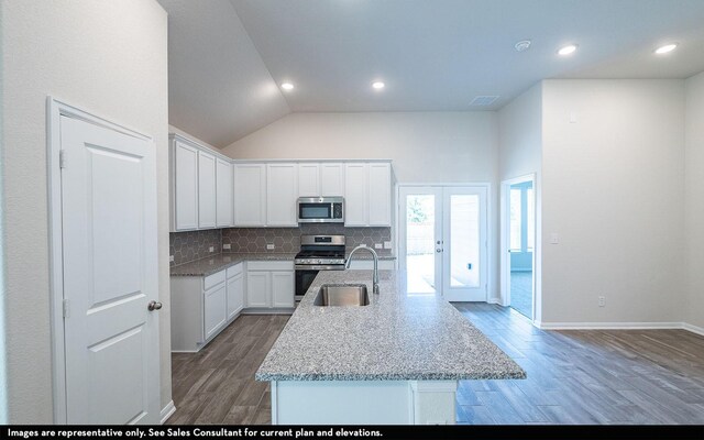 2476 Fairway Harbor Dr, Katy, TX 77493 - kitchen with stainless steel appliances, wood finished floors, backsplash, white cabinetry, and high vaulted ceiling