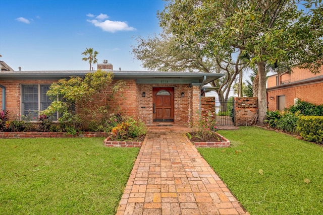 view of exterior entry with a yard