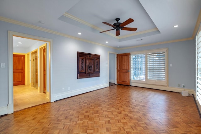 empty room with crown molding, light parquet flooring, ceiling fan, and a tray ceiling