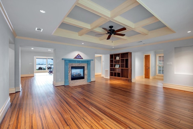 unfurnished living room with hardwood / wood-style floors, coffered ceiling, a fireplace, ornamental molding, and beamed ceiling