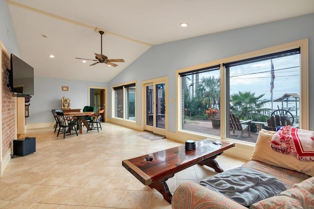 tiled living room featuring ceiling fan, a brick fireplace, a wealth of natural light, and lofted ceiling