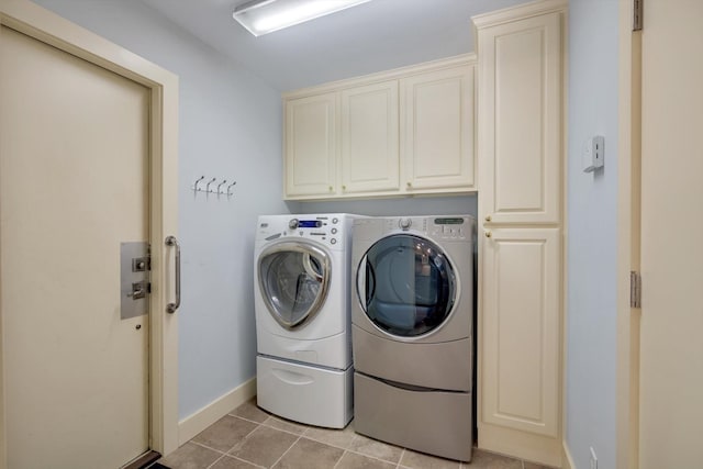 laundry room with cabinets, light tile patterned floors, and washer and clothes dryer