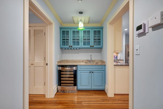 bar featuring light hardwood / wood-style floors, stainless steel fridge, beverage cooler, crown molding, and sink