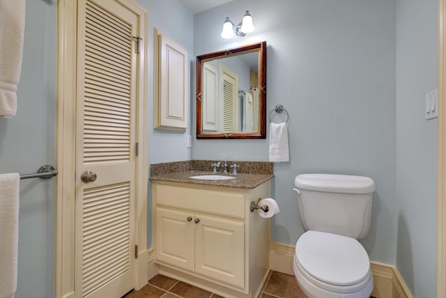 bathroom featuring toilet, vanity, and tile patterned flooring