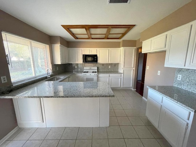 kitchen with light stone countertops, sink, white cabinetry, and white gas range oven