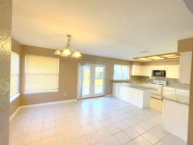 kitchen featuring white cabinets, hanging light fixtures, white gas stove, kitchen peninsula, and light tile patterned floors