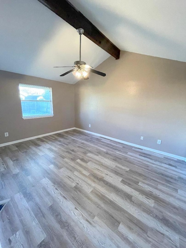 spare room featuring ceiling fan, lofted ceiling with beams, and light hardwood / wood-style floors