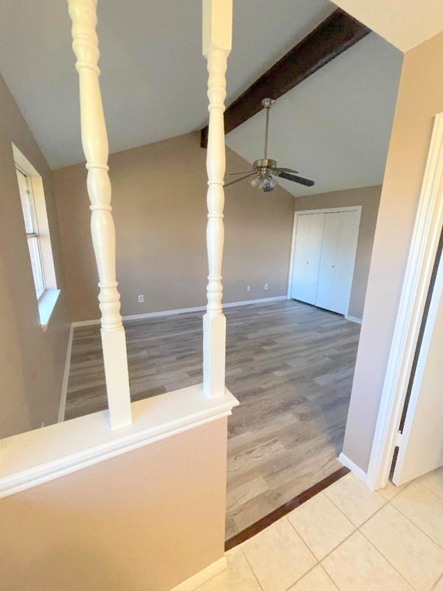 interior space with lofted ceiling with beams and tile patterned flooring