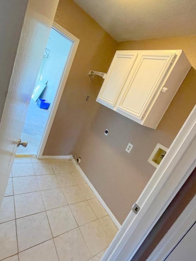 laundry area with washer hookup, cabinets, light tile patterned flooring, and hookup for an electric dryer