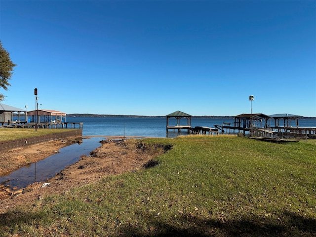 view of dock with a gazebo, a yard, and a water view