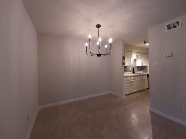 unfurnished dining area with sink, tile patterned floors, and a notable chandelier