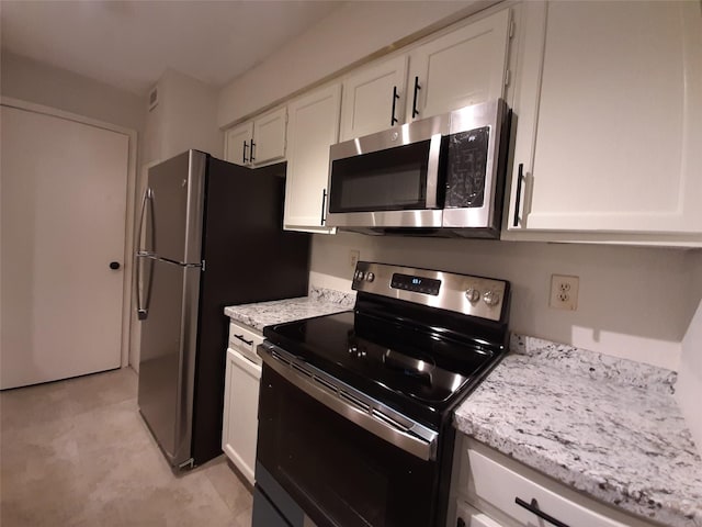 kitchen featuring white cabinets, light stone countertops, and stainless steel appliances