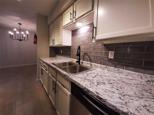 kitchen featuring decorative light fixtures, tasteful backsplash, light stone counters, and sink