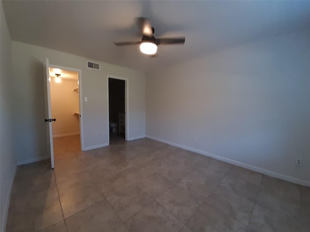 unfurnished bedroom featuring a spacious closet, a closet, ceiling fan, and tile patterned flooring