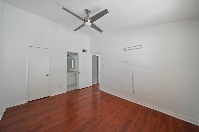 unfurnished bedroom featuring ceiling fan, dark wood-type flooring, and ensuite bath