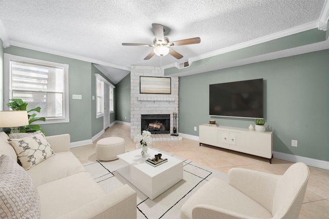 living room featuring a textured ceiling, a brick fireplace, light tile patterned floors, and crown molding