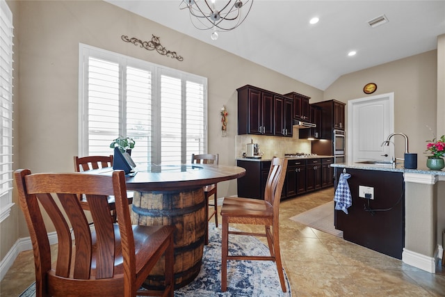 tiled dining space featuring lofted ceiling and sink