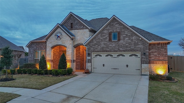 view of front of property featuring a garage and a lawn