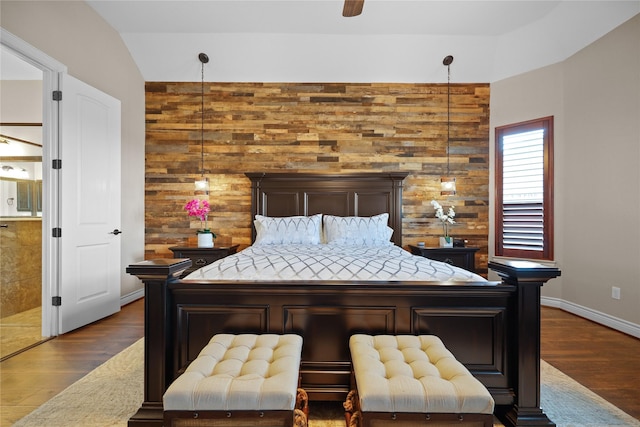 bedroom with ceiling fan, dark hardwood / wood-style floors, and wooden walls