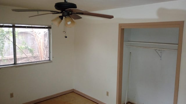 unfurnished bedroom with ceiling fan and a closet