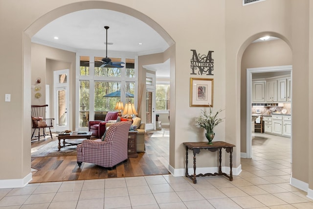 interior space featuring ceiling fan, light tile patterned floors, and ornamental molding