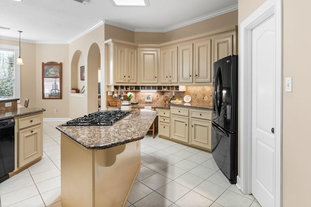 kitchen with dark stone countertops, a kitchen island, black appliances, a kitchen bar, and decorative backsplash