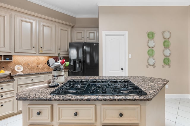 kitchen with black appliances, a center island, dark stone countertops, ornamental molding, and cream cabinetry