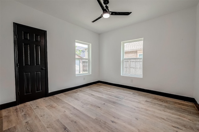 spare room with ceiling fan, plenty of natural light, and light hardwood / wood-style flooring