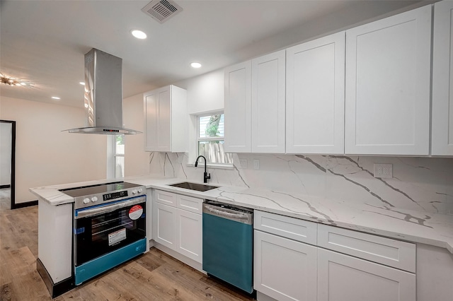 kitchen featuring white cabinetry, island exhaust hood, appliances with stainless steel finishes, tasteful backsplash, and sink