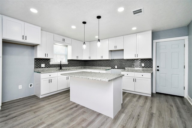 kitchen with white cabinetry, a center island, and pendant lighting