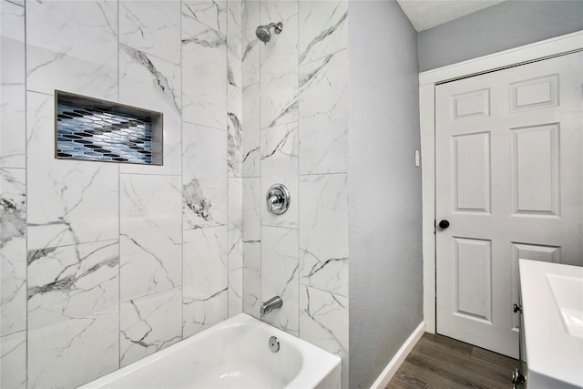 bathroom featuring tiled shower / bath combo, vanity, and hardwood / wood-style flooring