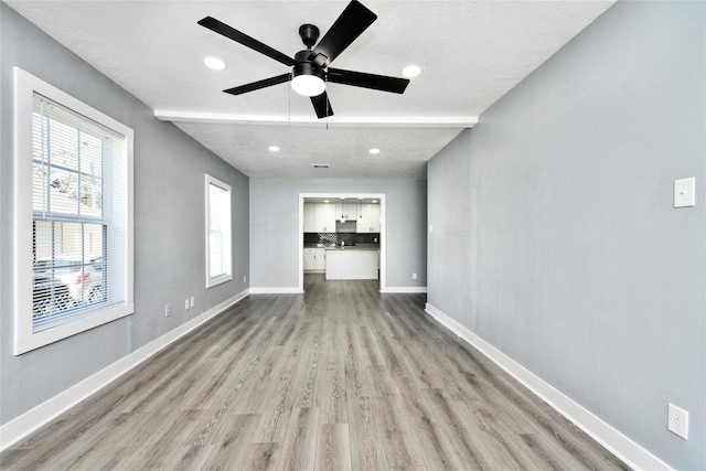 unfurnished living room featuring ceiling fan and light hardwood / wood-style floors