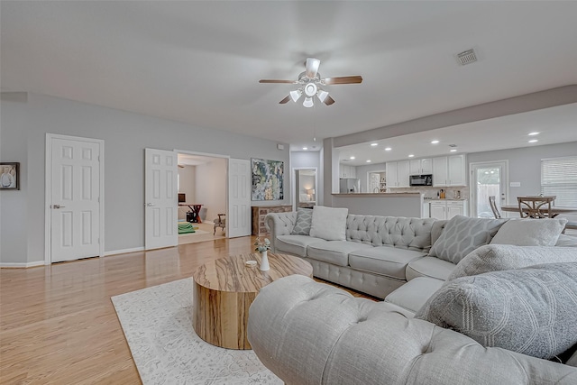 living room featuring light hardwood / wood-style floors and ceiling fan