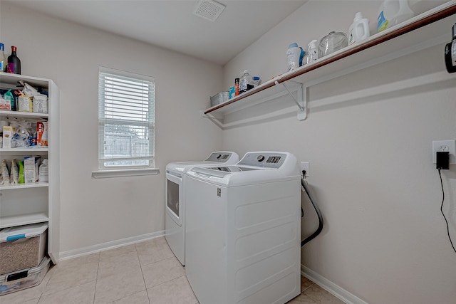 clothes washing area featuring light tile patterned floors and washer and clothes dryer