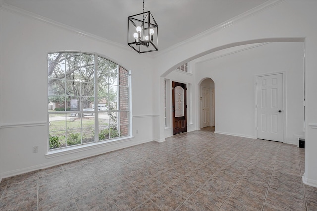 spare room with crown molding, a chandelier, and a wealth of natural light