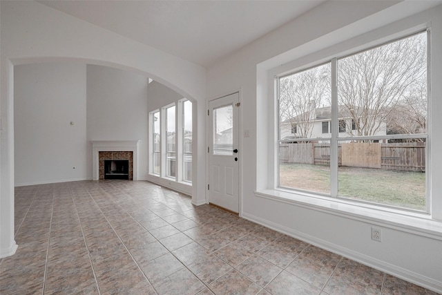 unfurnished living room with light tile patterned floors and a fireplace