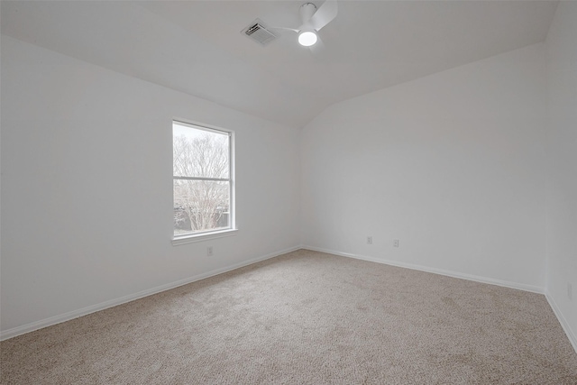 empty room featuring carpet floors, vaulted ceiling, and ceiling fan